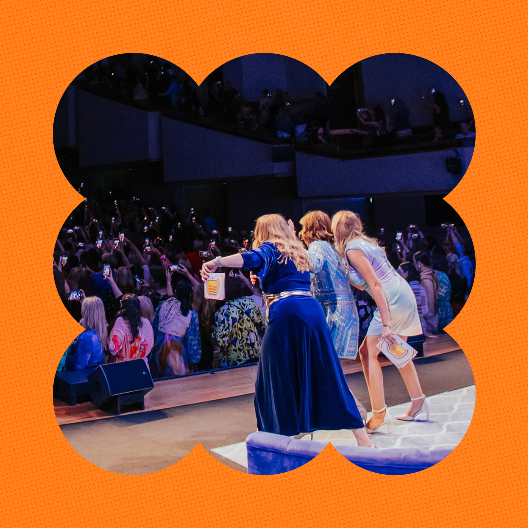 Mamamia Out Loud hosts on stage in front of a sold-out theatre